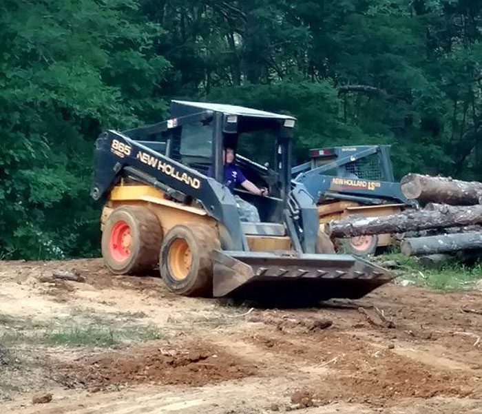 DeBord & Son Construction | clearing trees and debris from a site surrounded by trees